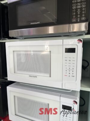 Two Frigidaire microwaves stacked in a showroom, stainless steel doors and perforated fronts visible on the units.