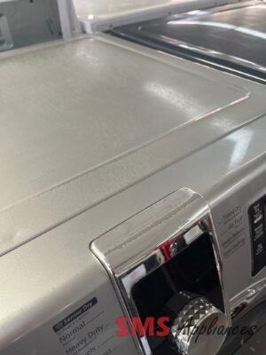 Silver front-loading washing machine with a rounded glass door and chrome trim, viewed from the side with a detergent panel visible at the bottom right.
